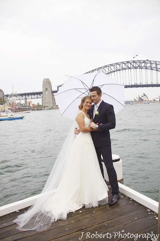 Couple in a pier with an umbrella on Sydney Harbour - wedding photography sydney